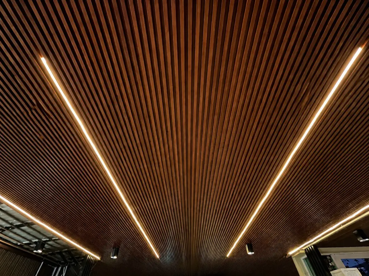 ฝ้าระแนงไม้เทียมโทนไม้เข้ม ไฟเส้นซ่อน 1200 — WPC Battens | NexSteel Solutions
