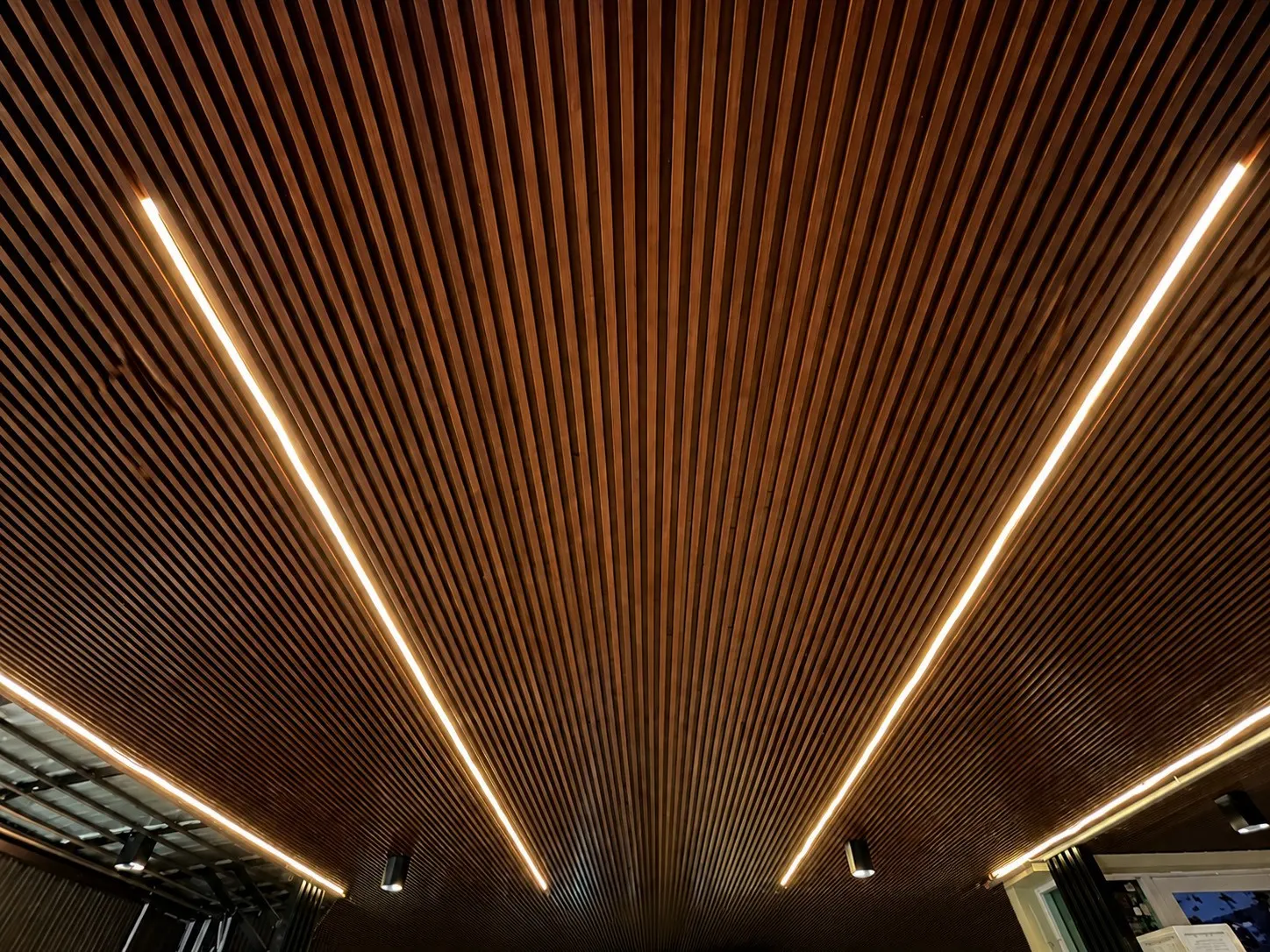 ฝ้าระแนงไม้เทียมโทนไม้เข้ม ไฟเส้นซ่อน — WPC Battens | NexSteel Solutions